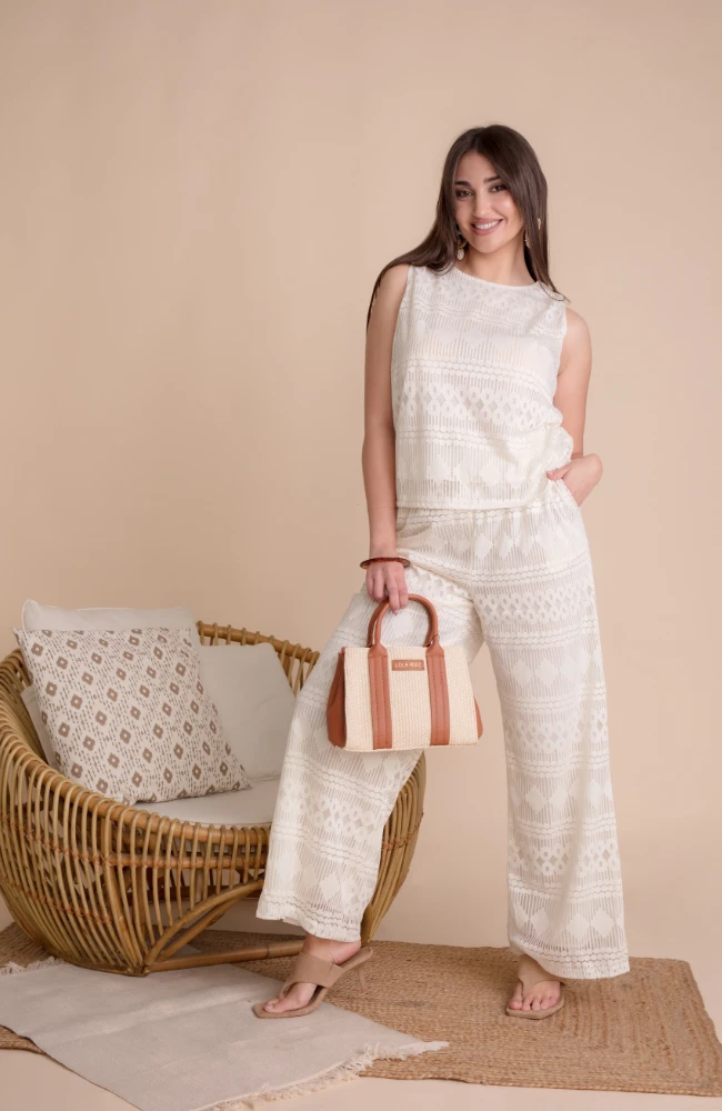 Conjunto de dos piezas calado en color blanco con pantalón fluido de Lola Ruiz.