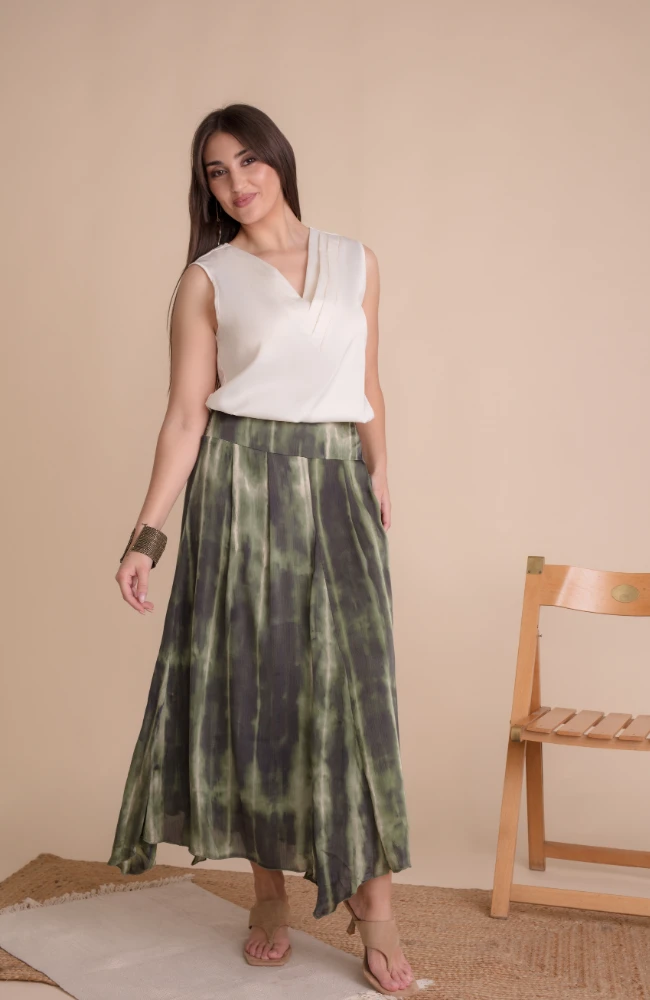 Falda larga con estampado tie-dye verde y blusa blanca escote en V de Lola Ruiz.