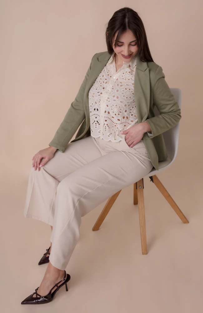 Blazer verde militar con camisa calada blanca y pantalón beige de Lola Ruiz.